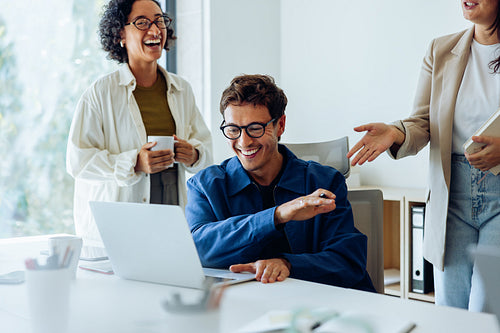 Colleagues laugh as they share ideas at work