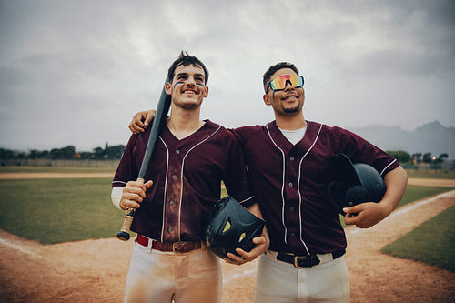 Two happy baseball players in uniform celebrating their team's victory