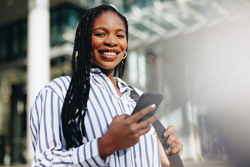 Young business woman smiling at the camera while commuting to her office in the city