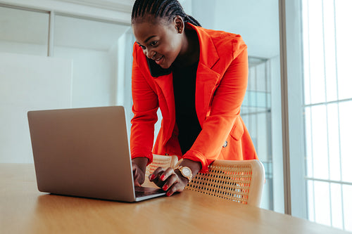 Confident professional woman multitasking with technology in a bright office setting