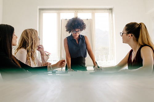 Woman discussing new project with colleagues in meeting
