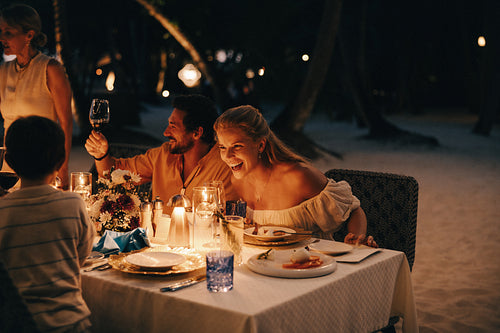 Family enjoying luxury dinner at a beachfront resort during vacation
