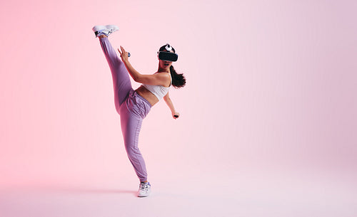 Young woman throwing a kick in a virtual reality game