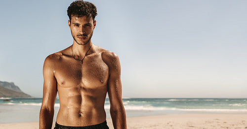 Man standing at the beach doing fitness training