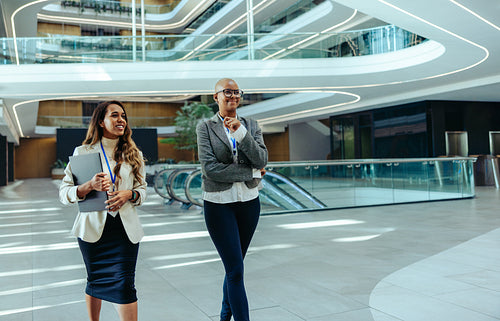 Confident female financial professionals walking in modern office