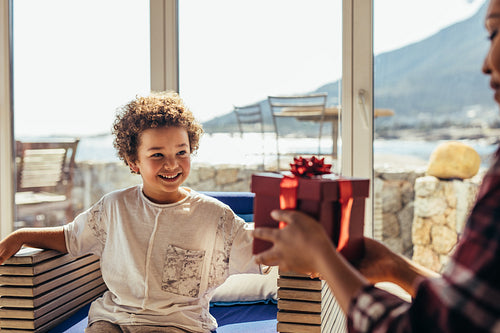 Close up of a woman giving a present to a kid.