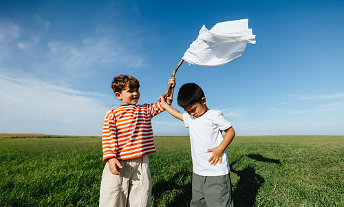Kids waving white flag in field symbolizing peace and unity