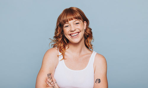 Happy red haired woman standing in a studio