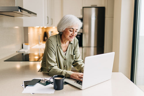 Self-employed senior woman working on her laptop at home