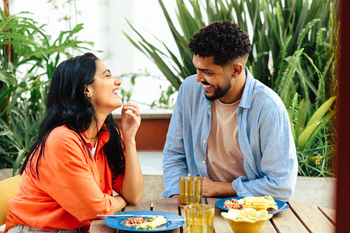 Happy Latino couple enjoying a casual meal together outdoors
