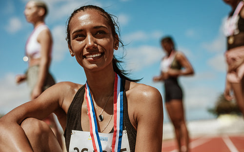Runner sitting on track after winning the race
