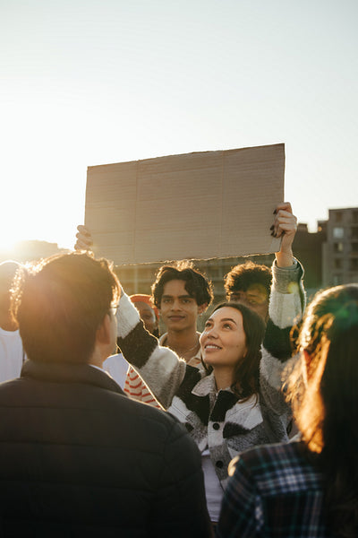 Young adults holding a sign during a peaceful outdoor protest