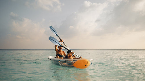Mother and child kayaking on a clear ocean during a serene day