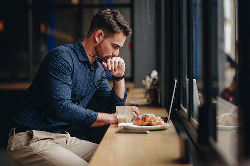 Businessman working on laptop sitting in a restaurant