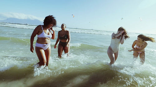 Different size women in bikinis having fun on the beach