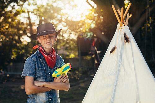 Little cowboy in backyard with water gun