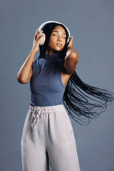 Girl with braids listening to her favoutite music on headphones