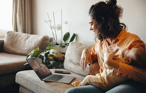 Mother with baby on couch during video call