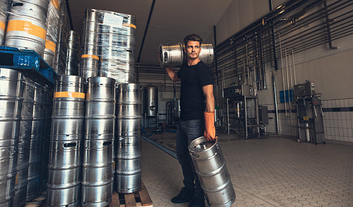 Brewer carrying keg at brewery factory