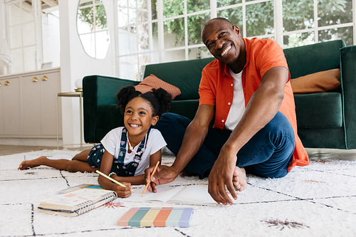 Father and daughter bonding over art project at home