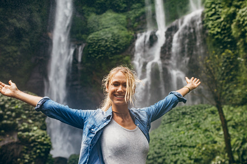 Tourist with tropical waterfall in background