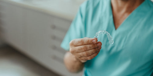 Close-up of dental aligner in dental professional's hand