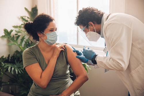 Frontline worker vaccinating woman at her home