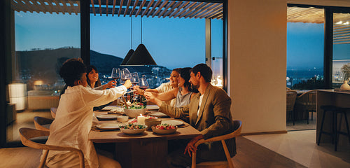 Friends enjoy a relaxed evening meal together at home with scenic views