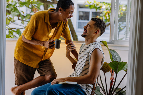 Happy couple enjoying a laugh together at home with natural lighting