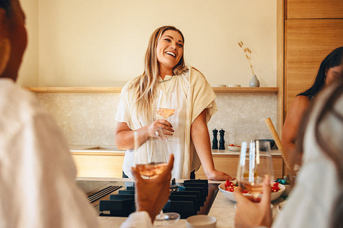 Woman enjoying a social evening with friends in a cozy kitchen setting