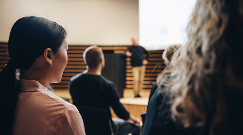 Businesswoman sitting in audience at corporate event
