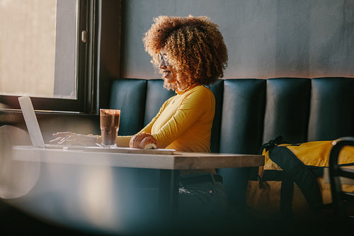 Freelancer woman working on laptop sitting at a restaurant
