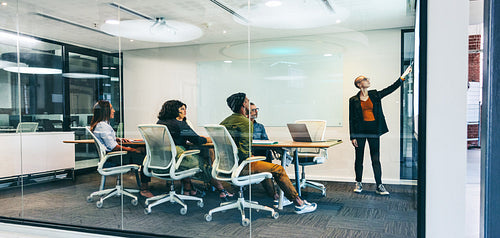 Confident young businesswoman giving a presentation in a boardroom