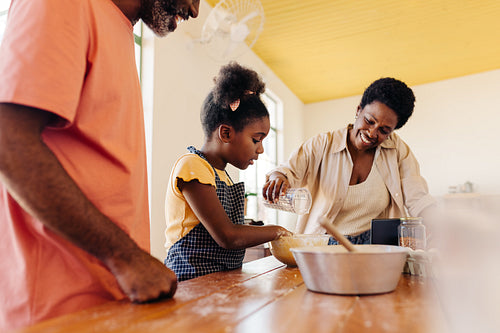 Girl baking bolo de fubá with her parents in a Brazilian kitchen