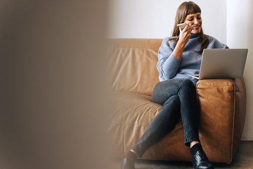 Cheerful businesswoman taking a phone call in an office lobby