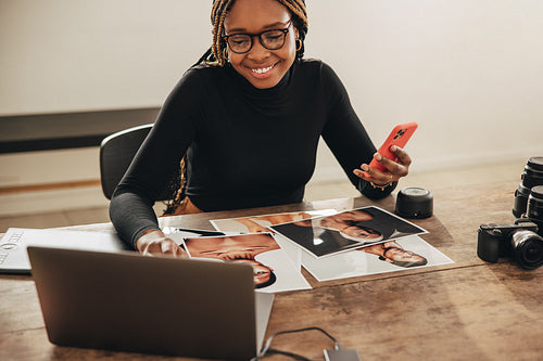 Artist using a laptop and a smartphone in her office