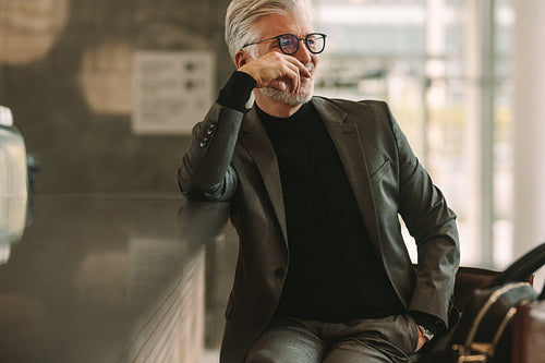 Businessman sitting at cafe and looking away