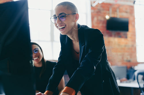 Young businesswoman using a desktop while working with her colle