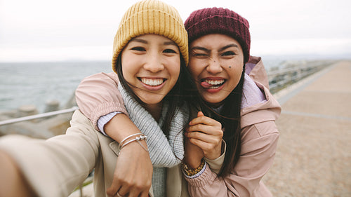 Cheerful women friends having fun standing outdoors