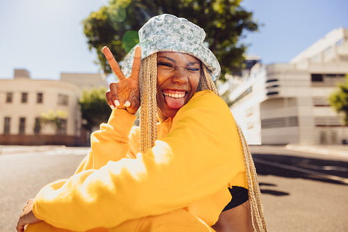 Carefree young woman making the peace sign