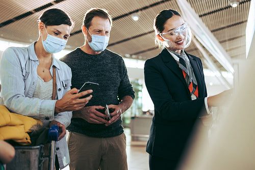 Ground staff helping couple in face masks