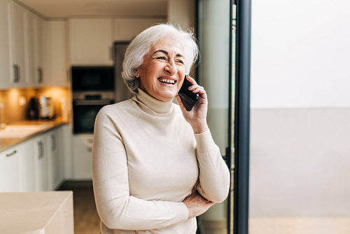 Senior woman speaking on a phone call at home