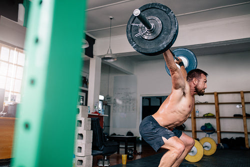 Powerful bodybuilder heavy lifting at the gym