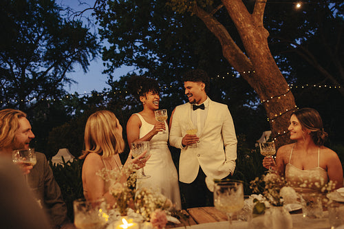 Beautiful couple celebrates an evening wedding outdoors with close family and friends