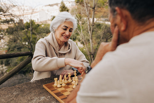 Lovely senior couple playing a game of chess outdoors
