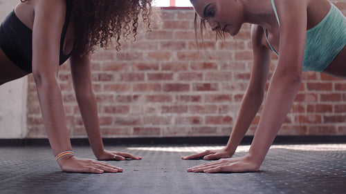 Two women doing push-ups and clapping hands