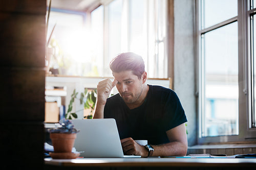 Business man thinking about a problem at his laptop