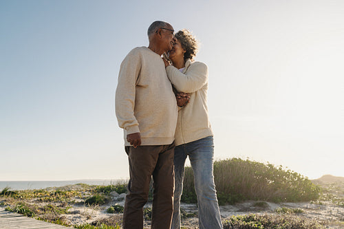 Senior woman whispering to her husband at the beach