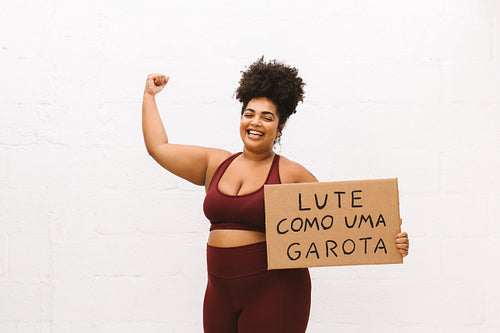 Confident woman with "Fight like a girl" signboard