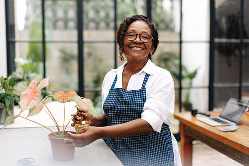 Portrait of a female florist watering a floral plant